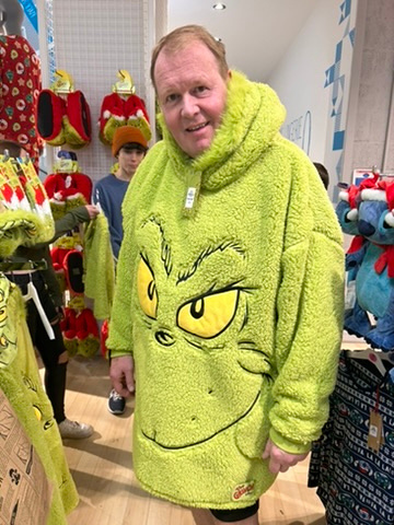 Craig wearing a grinch hoodie in the middle of the shop